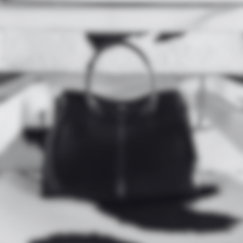 Black leather handbag on a light gray surface